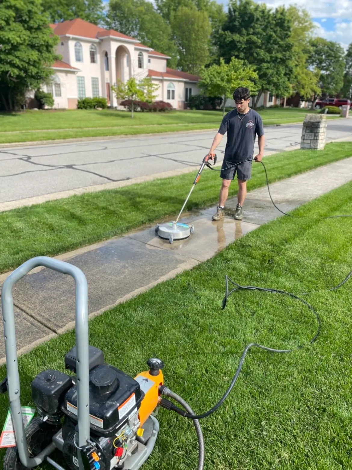 Sidewalk pressure washing with freshly mowed lawn