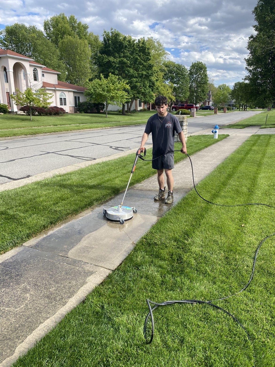 Sidewalk pressure washing with freshly mowed lawn